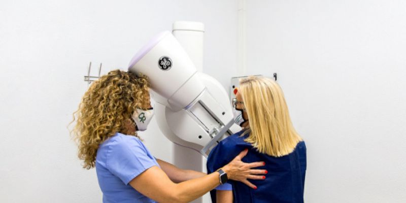 Técnico y paciente haciendo una mamografía