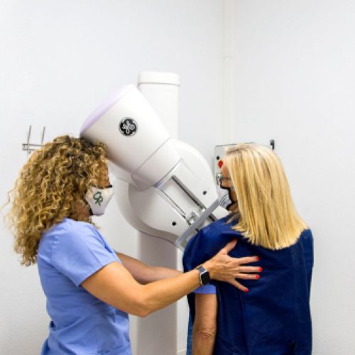 Técnico y paciente haciendo una mamografía
