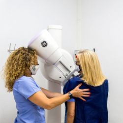 Técnico y paciente haciendo una mamografía